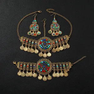Vue detaillee de l ensemble de bijoux ethniques vintage dores avec pampilles et perles colorees.