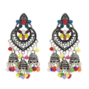 Vintage bohemian colorful enamel jhumka tassel earrings detail view, ethnic Indian style.