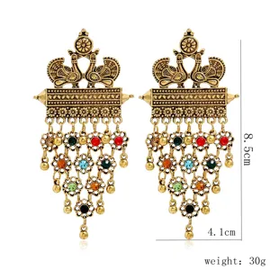 Close-up detail of retro ethnic peacock drop earrings with multi-color rhinestones.