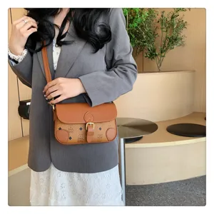 Vintage contrast color shoulder bag with retro monogram pattern and chic buckle closure.