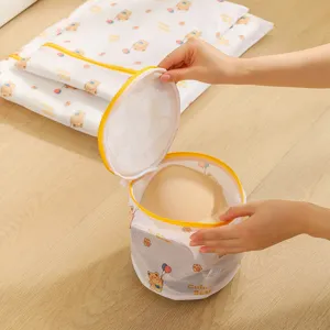 Cartoon bear print fine mesh cylindrical laundry bag with yellow zipper for bra washing.