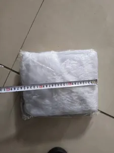 Dettaglio della gonna per albero di Natale in peluche bianco con nastro di misurazione.