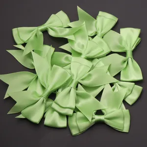 Light green satin ribbon bows detail showing smooth fabric texture for DIY crafts and gifts.