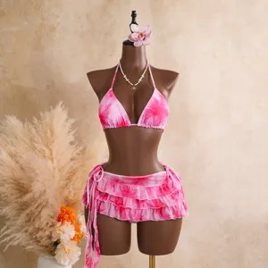 Détail de bikini imprimé floral rose, haut dos nu et jupe à volants sur mannequin.