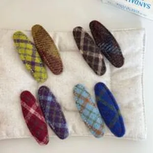 Detailed view of colorful tweed plaid hair clips, textured fabric duckbill clips for daily wear.