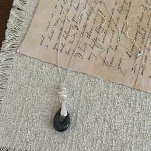 Dettagli della lunga catena maglione vintage neo-cinese con ciondolo geometrico e argento.