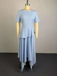 Light blue dress detail showing short sleeves, round neck and asymmetrical ruffled hemline.