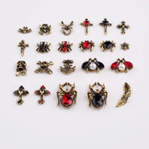 Vue détaillée des breloques d'ongles gothiques, araignées en métal vintage et strass de croix pour déco.