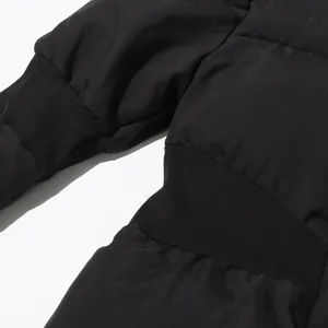 Close-up detail of black winter puffer jacket featuring warm ribbed cuffs and textured fabric.