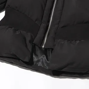 Black quilted cotton coat detail shot, featuring front zipper and chic peplum hem design.