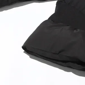 Detailed view of women's black padded winter coat featuring a stylish trumpet sleeve cuff.