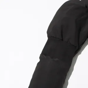 Close-up detail of black winter jacket sleeve with ribbed cuff, soft quilted fabric.