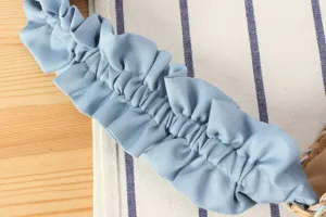 Detail de bandouliere de sac fronce bleu, design de plis nuage en tissu doux, accessoire elegant.