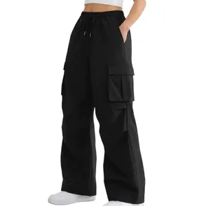 Dettaglio dei pantaloni cargo neri con design tasche multiple e vita regolabile.