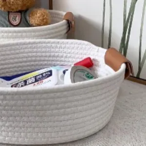 White cotton rope woven storage basket with leather handles, perfect for home desktop organizer.
