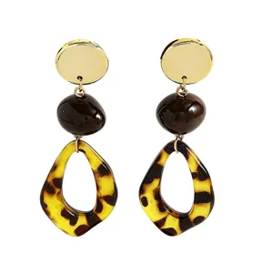 Detailed close-up of fashionable tortoiseshell leopard print resin drop dangle earrings.