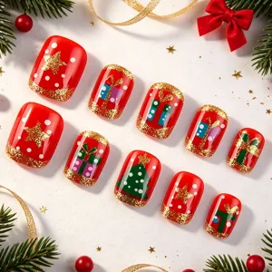 Primer plano de uñas postizas cuadradas cortas con diseño navideño rojo y purpurina dorada.