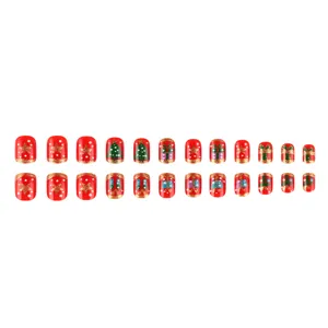 Vista detallada de uñas postizas cuadradas cortas con lindos patrones de árboles de navidad y regalos.