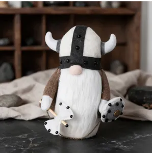 Close-up of a cute Viking gnome plush doll with a horned helmet, holding an axe and a shield.