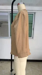 Detailansicht eines einfarbigen khaki langärmeligen V-Ausschnitt Damen-Tops auf Schaufensterpuppe.