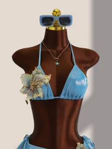 Gedetailleerd uitzicht van de lichtblauwe glinsterende bikini met groot bloemborduurwerk.