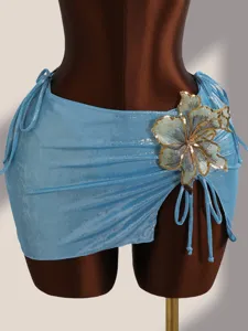 Detailweergave van glinsterende blauwe bikinirok met pailletten geborduurde bloemaccent.