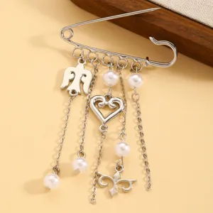 Detailed view of silver brooch with pearls and charms, elegant accessory close-up shot.