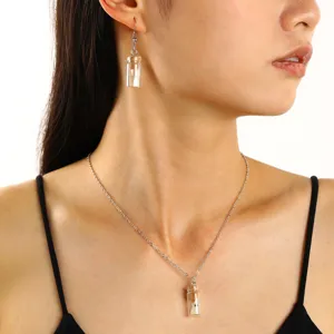 Gros plan détail du collier pendentif bouteille fantôme lumineuse Halloween et boucles d'oreilles.