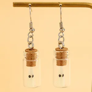 Gros plan détaillé des jolies boucles d'oreilles fantôme lumineux en verre pour fête.
