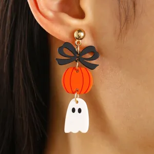 Detalle de primeros planos de pendientes de Halloween con calabaza y un fantasma.