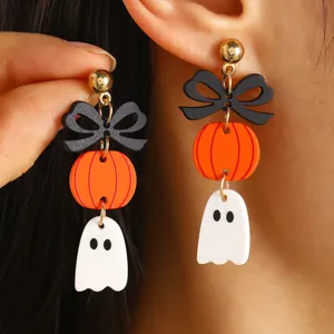 Primer plano detallado de pendientes de Halloween con calabaza y fantasma de acrílico.