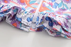 Kinderbadeanzug Detailansicht, Nahaufnahme von Blumenmuster, Reißverschluss und Rüschen.