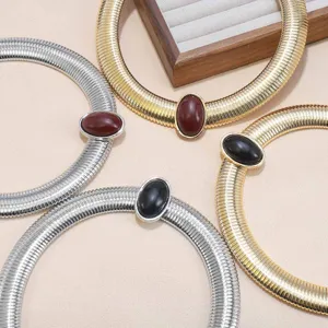 Chunky snake bone choker necklace with oval gemstone, stylish metal collar jewelry for women.