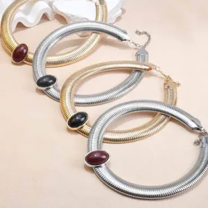 Detail shot of chunky metal snake bone chain choker necklaces with oval gemstone pendants.