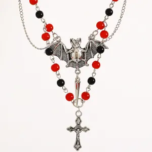 Primo piano della collana con ciondolo a pipistrello gotico con perle rosse e nere belle.