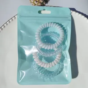 Close-up detail of candy color telephone wire hair ties in blue pouch, elastic spiral bands.