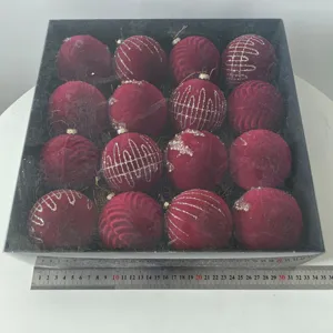 Set de bolas de Navidad de terciopelo burdeos con diseños brillantes en caja de regalo negra.