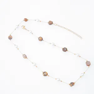 Close-up detail of irregular natural stone and pearl bracelet, delicate 18k gold plated chain.
