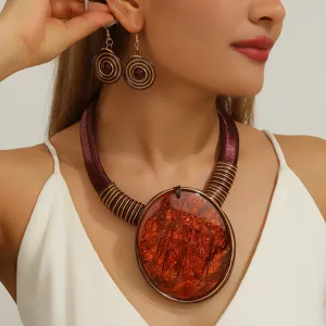 Gros plan détail du collier statement audacieux et des boucles d'oreilles spirales mode.