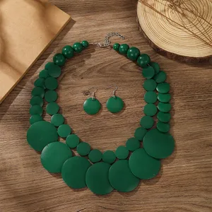 Detalles del conjunto de collar y pendientes de cuentas de madera verde en estilo bohemio.