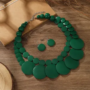Detalle del conjunto de collar y pendientes de cuentas de madera verde estilo boho.