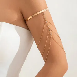 Bracciale da braccio dorato con nappe di catena in strass multistrato, gioiello moda chic.