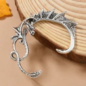 Detailed close-up of a retro silver dragon ear cuff, showcasing intricate wings and scale textures.