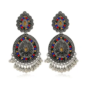 Close-up detail of antique silver carved bohemian ethnic earrings with colorful crystal stones.