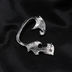 Detail close-up of punk retro silver dragon wing ear cuff, gothic metal fashion jewelry.