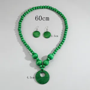 Vista dettagliata del set di collana con perle di legno verde e orecchini coordinati.