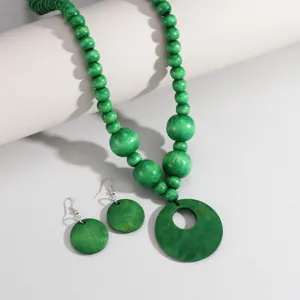 Set di collana e orecchini di perline di legno verde con ciondolo rotondo in stile.