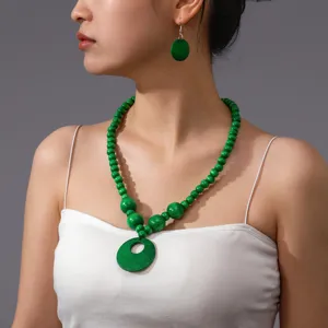 Primo piano dettagliato della collana di perle di legno verde e orecchini abbinati.