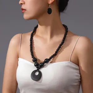 Set collana e orecchini in perle di legno nero fatto a mano, vista di dettaglio per lo stile.