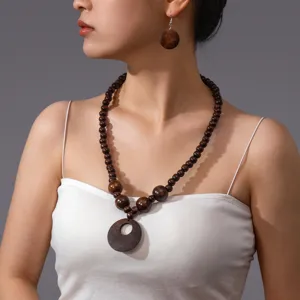 Dettaglio in primo piano di collana di perline di legno scuro e orecchini set.